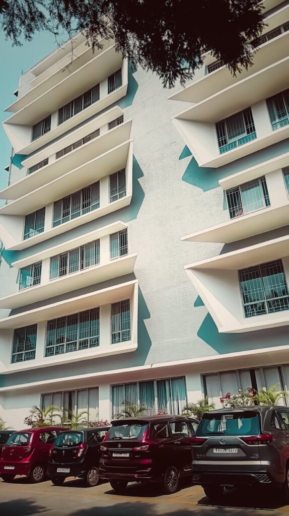 pexels-photo-34698803 Urban building architecture with parked cars in BR, India